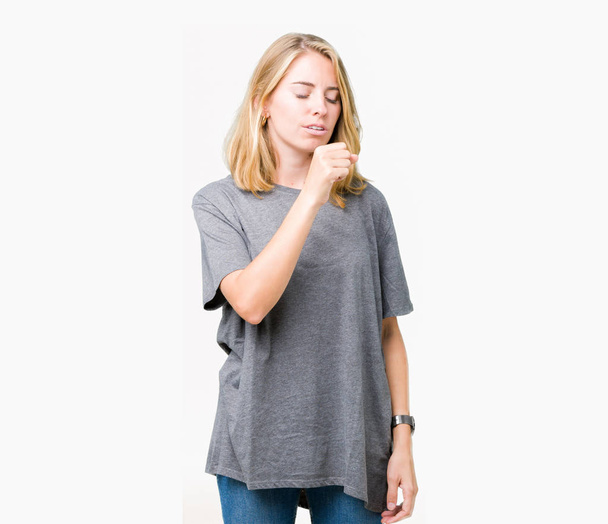 Mooie jonge vrouw oversize casual t-shirt dragen over geïsoleerde achtergrond gevoel onwel en hoesten als symptoom voor koude of bronchitis. Gezondheidszorg concept. - Foto, afbeelding
