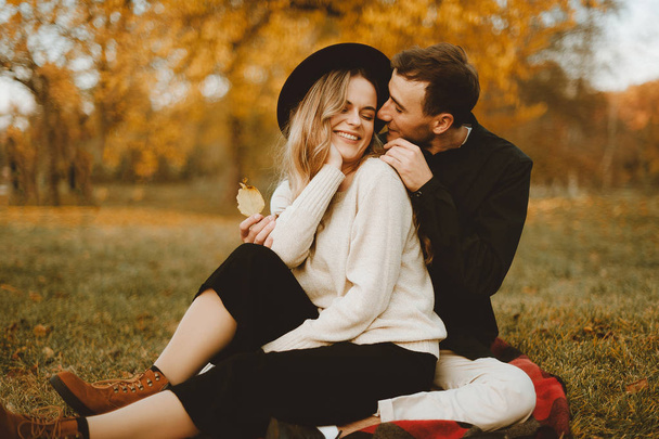 Hermosa pareja joven de chica bonita y hombre hipster sentado en el parque
 - Foto, Imagen