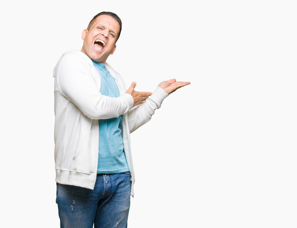 Middle age arab man wearing sweatshirt over isolated background Pointing to the side with hand and open palm, presenting ad smiling happy and confident - Φωτογραφία, εικόνα