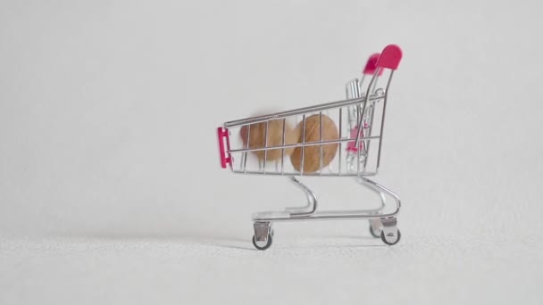 Shopping cart from the supermarket filled with walnuts nuts. walnuts fall in the supermarket cart. - Séquence, vidéo