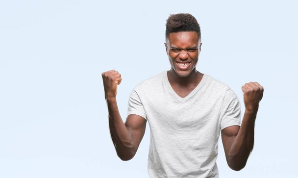 Young african american man over isolated background celebrating surprised and amazed for success with arms raised and open eyes. Winner concept. - Photo, image