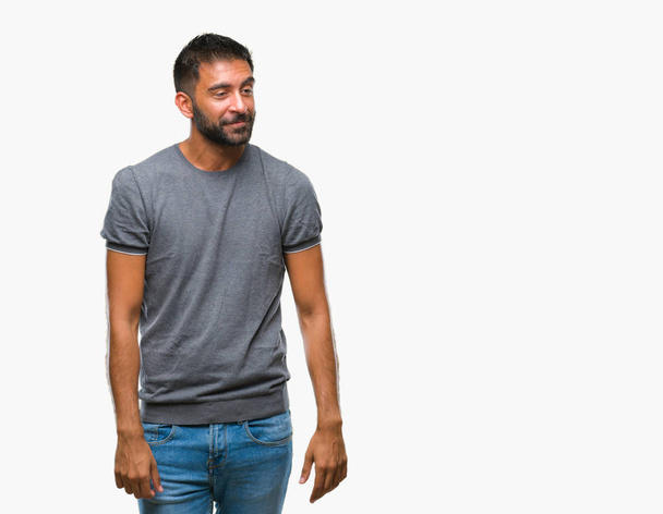 Adult hispanic man over isolated background looking away to side with smile on face, natural expression. Laughing confident. - Photo, Image