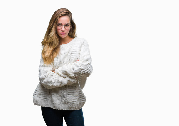 Young beautiful blonde woman wearing winter sweater and sunglasses over isolated background skeptic and nervous, disapproving expression on face with crossed arms. Negative person. - Foto, Imagem