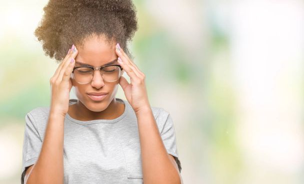 若いアフロ アメリカ人女性にメガネをかけて頭の頭の中の痛みのために手でバック グラウンドを分離は、のでストレス。片頭痛に苦しんでいます。. - 写真・画像
