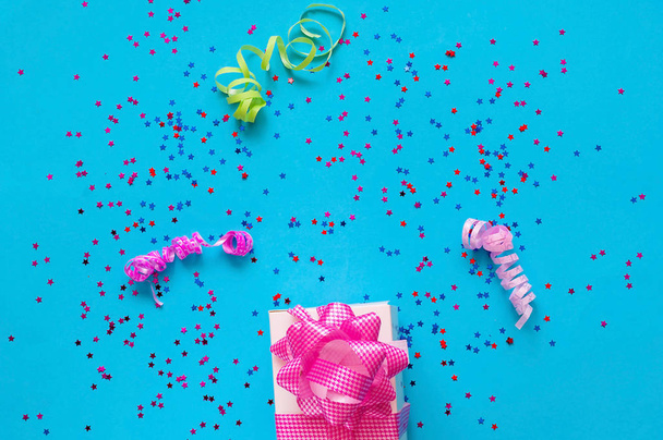 Geschenkdoos met roze strik op blauwe achtergrond met schittert. Feestelijke concept.   - Foto, afbeelding