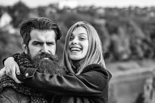 Young happy couple of pretty girl and bearded man hipster embracing outdoors in park on autumn day on natural background - Foto, Imagen