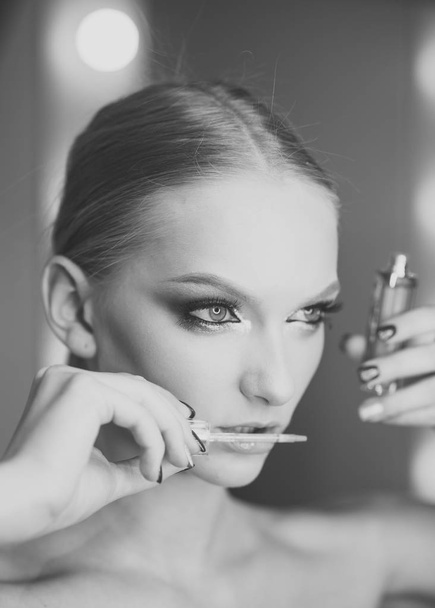 Beautiful woman applying lipstick gloss, studio shoot - Foto, immagini