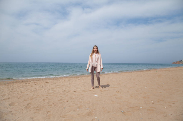 woman walking on sandy beach, one sea coast - Фото, изображение