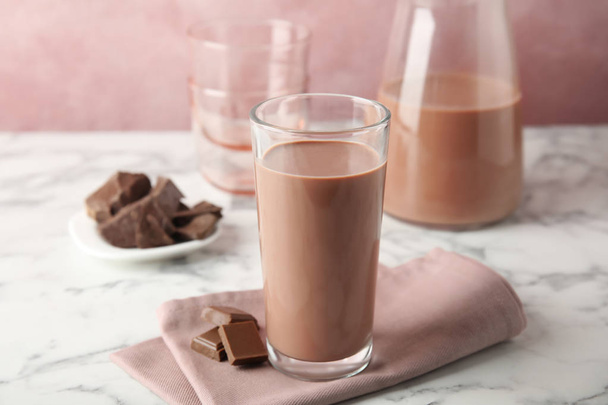 Glass with tasty chocolate milk on marble table. Dairy drink - Foto, Imagem