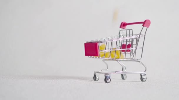 small shopping cart with pasta. pasta fall into shopping basket. - Video, Çekim