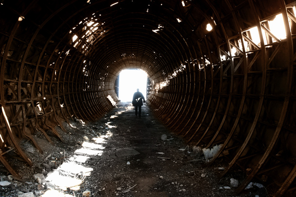 Viejo metal oxidado agujero tonelny hangar fortificado con silueta fantasma místico del hombre como base para el fondo surrealista
 - Foto, imagen