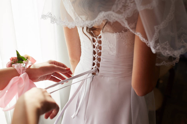 διευκολύνοντας τη νύφη να βάλει νυφικό της στο - Φωτογραφία, εικόνα