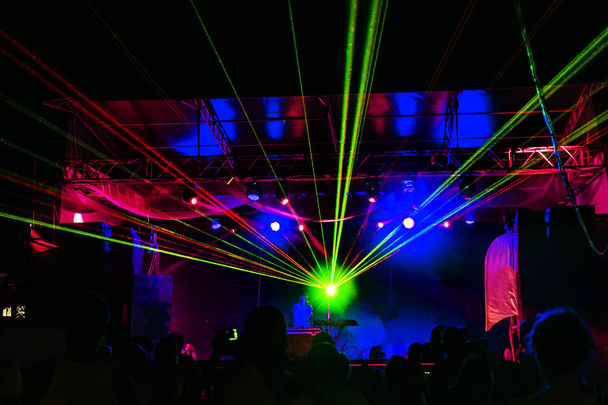 ライトが表示されます。レーザー ショー。夜のクラブ dj のパーティーの人々 は、カラフルな光と音のダンス音楽のお楽しみください。クラブ夜光 dj パーティー。スモーク マシンとライト。明るいパフォーマンス レーザー光のショー - 写真・画像