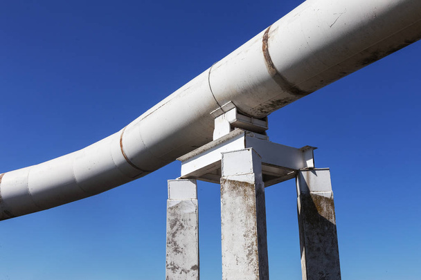 Tube de tuyau extérieur d'oléoduc de grande taille. Inscription en russe : Le pétrole est dangereux. Les gros tuyaux courbés du pipeline sont isolés avec des matériaux spéciaux. Au-dessus du sol
. - Photo, image