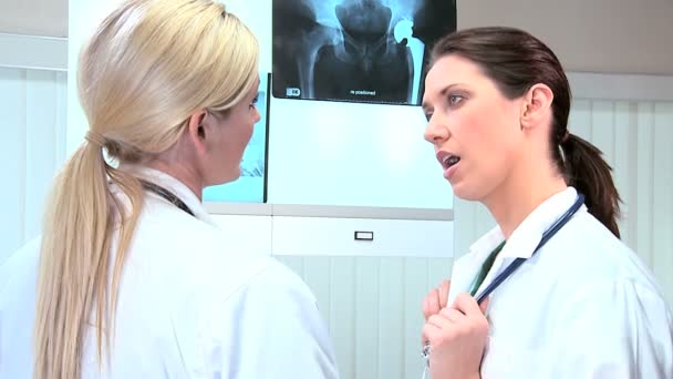 Médicos femeninos inspeccionando los resultados de rayos X
 - Metraje, vídeo