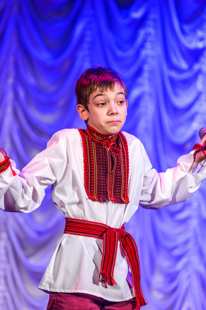 Odessa, Ukraine - December 24, 2015: Children's musical groups singing and dancing on stage in bright colorful clothes. Emotional, touching children's musical stage show. - Photo, Image