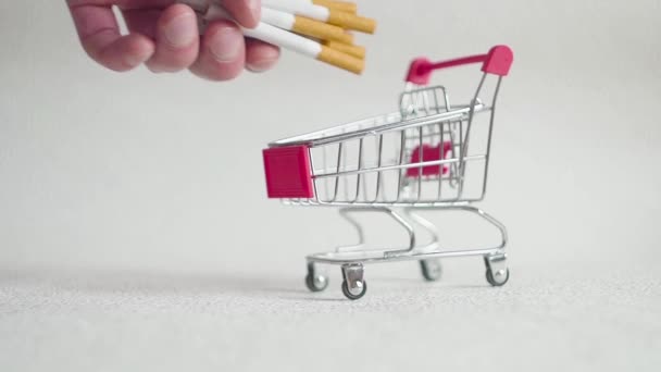 Cigarettes in shopping cart. Cigarettes in supermarket trolleys. Concept on health and addiction. - Footage, Video