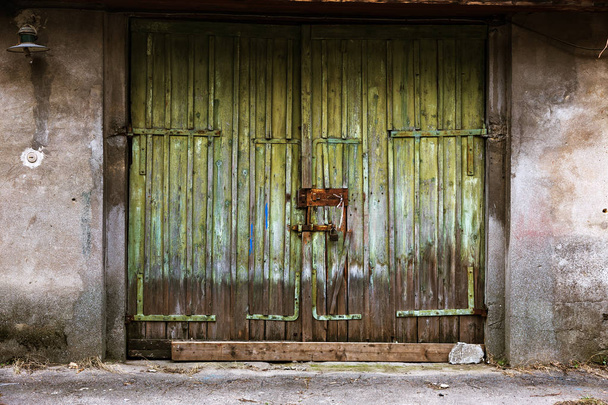alte Holztür im Armenviertel. uraltes Holz in einer alten Mauer. Zerstörungsspuren, Holztor und Zaun, rostige Metallnägel. konzeptioneller Hintergrund von Ruin und Armut - Foto, Bild