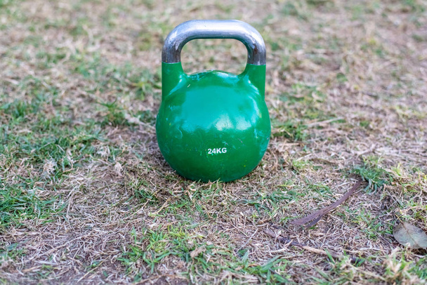 Kettlebell on the lawn for outdoor strength exercise. - Photo, Image