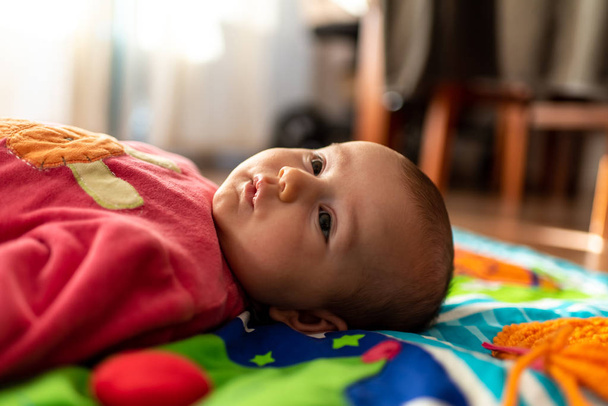 Bebê recém-nascido descansando relaxado face para cima em um tapete
. - Fotografia, imagem