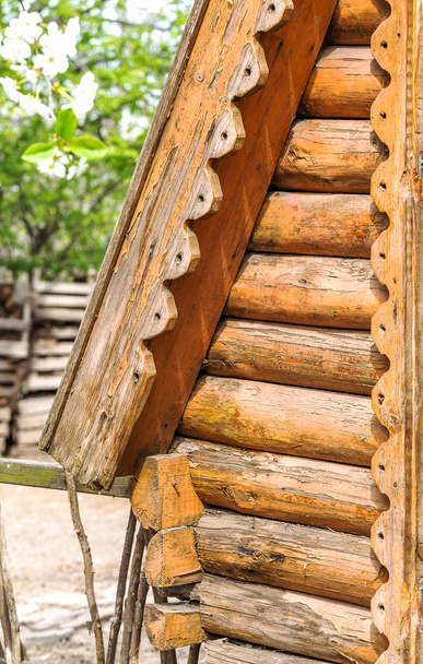 Λεπτομέρεια από ξύλινα δοκάρια στον τοίχο του κούτσουρου γύρο σπίτι χτισμένο σε παλιά τεχνολογία ως ένα δημιουργικό στοιχείο σε φυσικό υπόβαθρο - Φωτογραφία, εικόνα