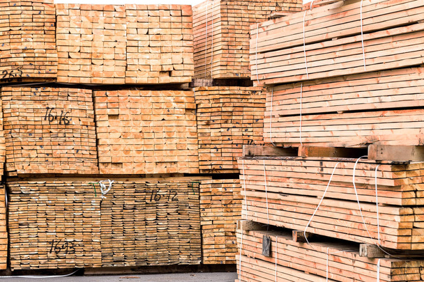 Uma pilha de placas afiadas de madeira embaladas em pilhas com parâmetros de tamanho de etiquetas para carregar guindastes e transportar os navios de carga no porto
  - Foto, Imagem