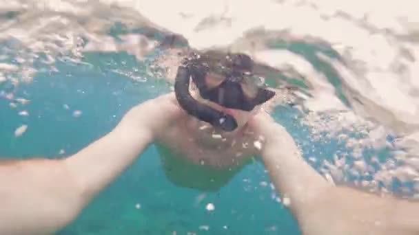 Portrait young man in snorkeling mask and snorkel swimming underwater sea and shooting selfie video. Man snorkeling in mask and snorkel under transparent sea water. - Footage, Video