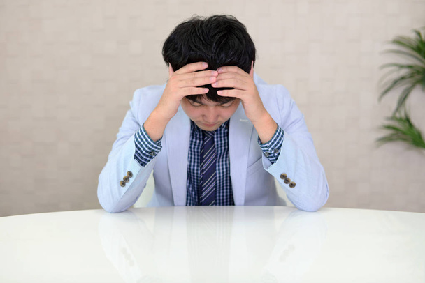 Disappointed Asian businessman at his office - Photo, Image