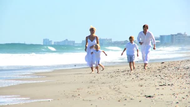Jovem família caucasiana correndo na praia
 - Filmagem, Vídeo