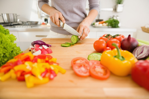 Closeup on young woman slicing vegetables - Foto, Imagen