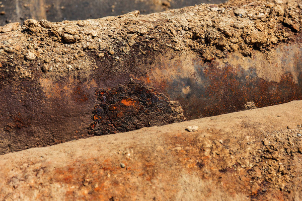 Fragments of old large water pipes. After many years of operation, destroyed metal pipe was destroyed. Vegetable steel tube with hole corrosion. Rusty metal pipe. Selective focus - Photo, Image
