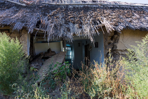 Παλιό αγρόκτημα αριστερά Ερειπωμένη Οικία. Καταστρέφεται με το χρόνο ένα εγκαταλελειμμένο σπίτι. Ερείπια του ένα εγκαταλελειμμένο σπίτι ερειπωμένο. Πώς καταθλιπτική υπόβαθρο για το σχεδιασμό thrash - Φωτογραφία, εικόνα