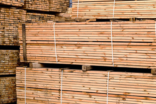 A pile of wood edged boards packed in stacks with tags size parameters for loading cranes and transport the cargo ships in the seaport  - Photo, Image
