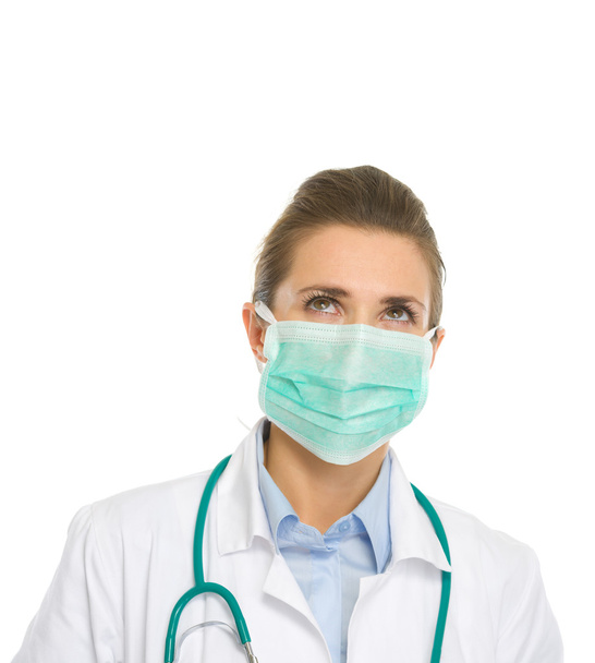 Medical doctor woman in mask looking up on copy space - Foto, Imagen