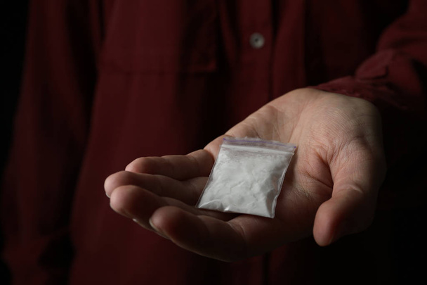 Drug dealer holding bag with cocaine, closeup - Photo, image