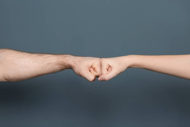 Young man and woman making fist bump on color background - Φωτογραφία, εικόνα
