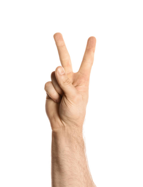 Young man showing victory gesture on white background - Foto, imagen