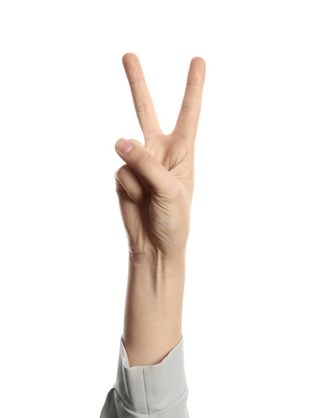 Young woman showing victory gesture on white background - Fotoğraf, Görsel