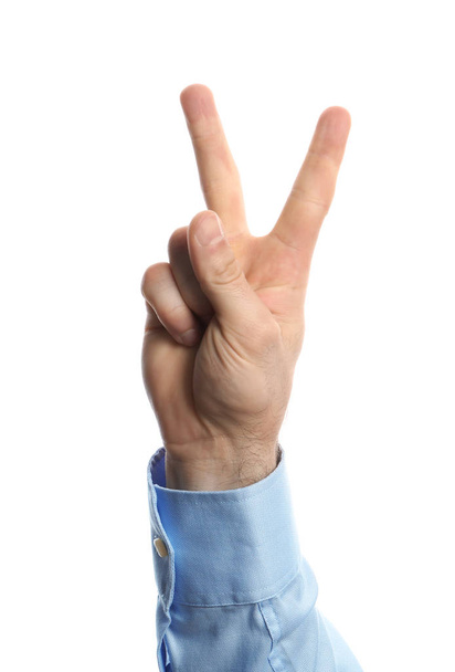 Young man showing victory gesture on white background - Foto, Imagen