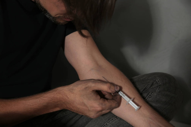 Male drug addict making injection, closeup of hands - Photo, image
