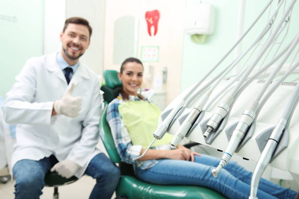 Professional dentist's equipment and blurred doctor with patient on background - Fotó, kép