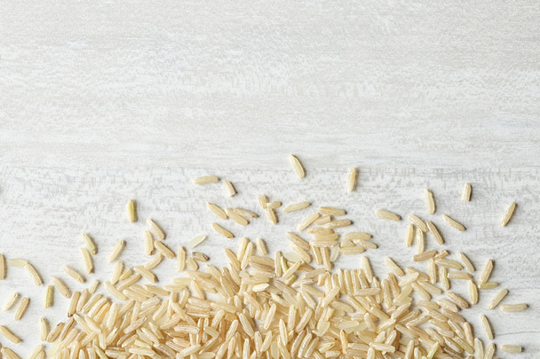 Brown rice on wooden background, top view with space for text - Foto, afbeelding
