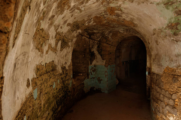 Un viejo túnel abandonado en una bodega subterránea. Entrada a catacumbas. Mazmorra Antigua fortaleza de piedra. Como fondo creativo para la puesta en escena del diseño oscuro. Interior místico de la antigua mazmorra
 - Foto, Imagen