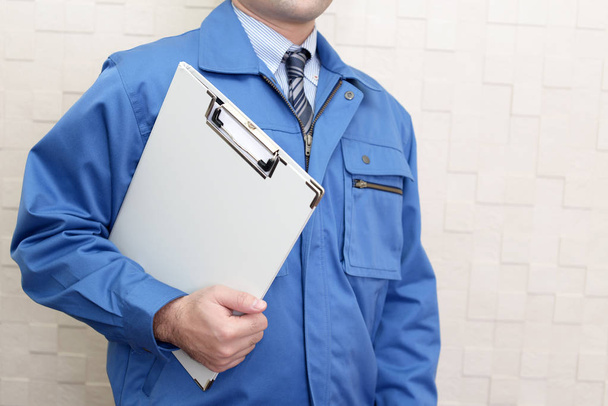 Trabalhador vestindo uniforme azul
 - Foto, Imagem