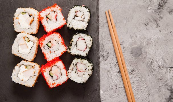 Rollos de sushi japoneses sobre fondo de piedra gris
. - Foto, Imagen