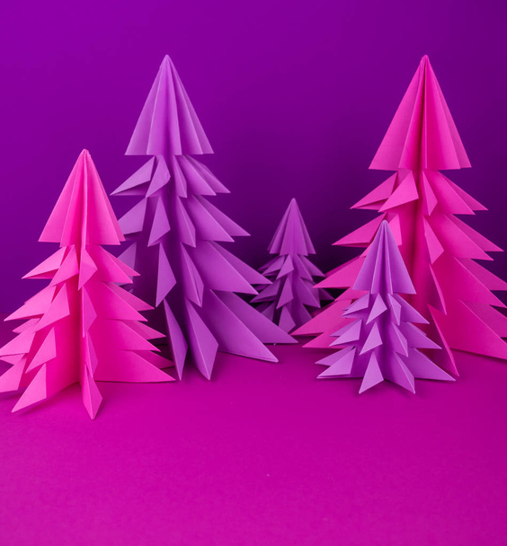 Christmas tree made of pink and purple craft paper. Handicraft. Violet background. Forest origami - Photo, image