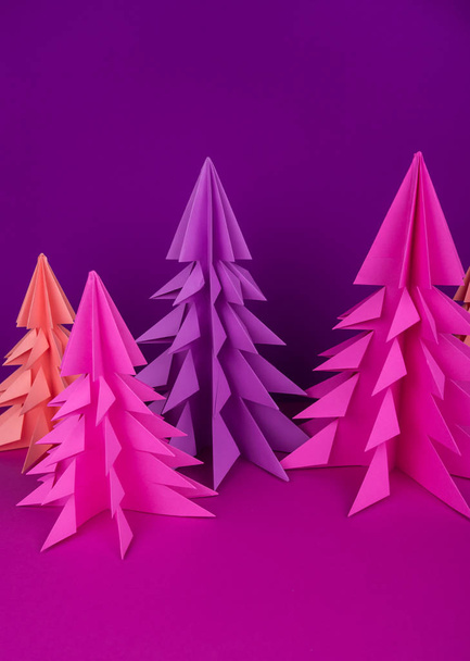 Christmas tree made of pink and purple craft paper. Handicraft. Violet background. Forest origami - Foto, afbeelding