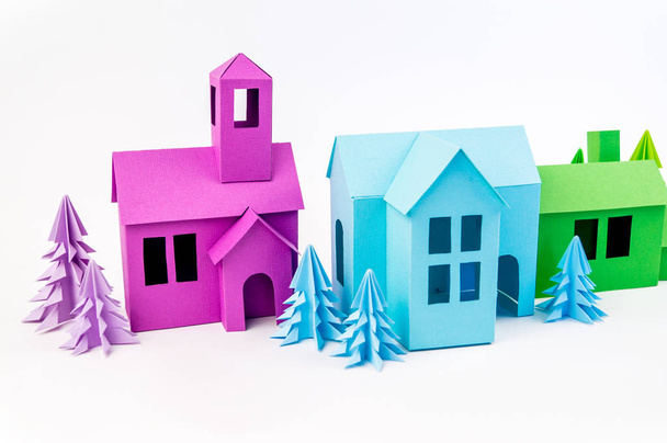 紫の森で紙から接着紫と青の緑の家が立っています。白い背景。子供の工芸品。クリスマス ツリー. - 写真・画像