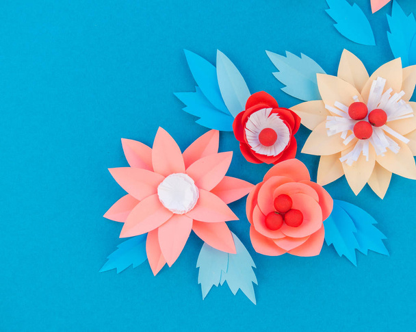 Paper flower for Christmas decor. Color coral fashion pastel. Handmade children's creativity. Blue background. Cozy new year. - Foto, imagen