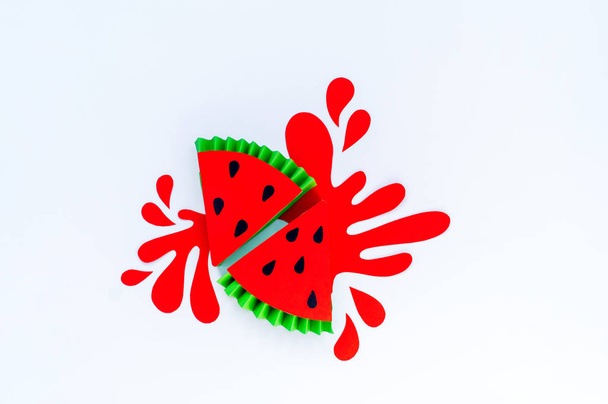 Red watermelon with splashes made of paper. White background. Fruit smoothies are vegetarian. Creating creativity with children. Slice - Valokuva, kuva